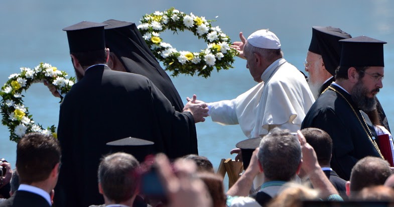 Papa Francesco e il Patriarca di Costantinopoli gettano delle corone di fiori in mare in memoria dei migranti morti nel tentativo di raggiungere l'isola di Lesbo. 